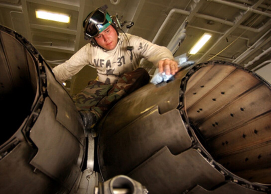 Petty Officer 2nd Class Christopher Shamblin wipes down the jet engine afterburner vanes on an F/A-18C Hornet in the hangar bay of the USS Harry S. Truman (CVN 75), on Feb. 22, 2005. The Truman Strike Group and Carrier Air Wing 3 are conducting close air support, intelligence, surveillance, and reconnaissance missions over Iraq. Shamblin is a Navy aviation structural mechanic assigned to Strike Fighter Squadron 37, of Naval Air Station Oceana, Va. 