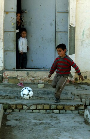CAMP TAQADDUM, Iraq (March 7, 2005) -An Iraqi child plays with the soccer ball given to him by American service members during a civil affairs mission to Al Kabani March 5. Marines from the 1st and 2d Force Service Support Groups (Forward), and soldiers from the Army's 2nd Battalion, 112th Armor, 36th Infantry, distributed humanitarian aid supplies and soccer balls to the town of about 60 homes. (Photo by Cpl. John E. Lawson Jr.)