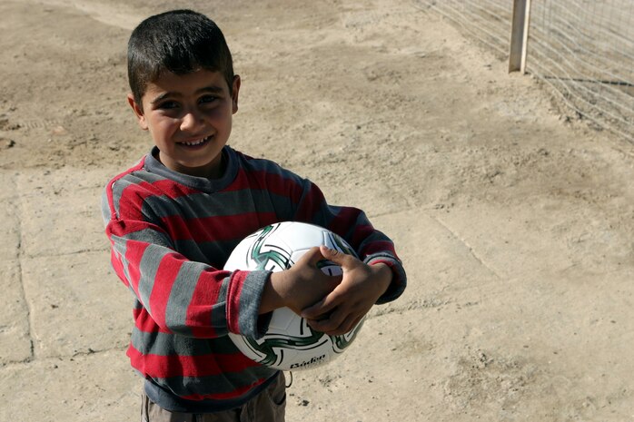 CAMP TAQADDUM, Iraq (March 7, 2005) -An Iraqi child plays with the soccer ball given to him by American service members during a civil affairs mission to Al Kabani March 5. Marines from the 1st and 2d Force Service Support Groups (Forward), and soldiers from the Army's 2nd Battalion, 112th Armor, 36th Infantry, distributed humanitarian aid supplies and soccer balls to the town of about 60 homes. (Photo by Cpl. John E. Lawson Jr.)