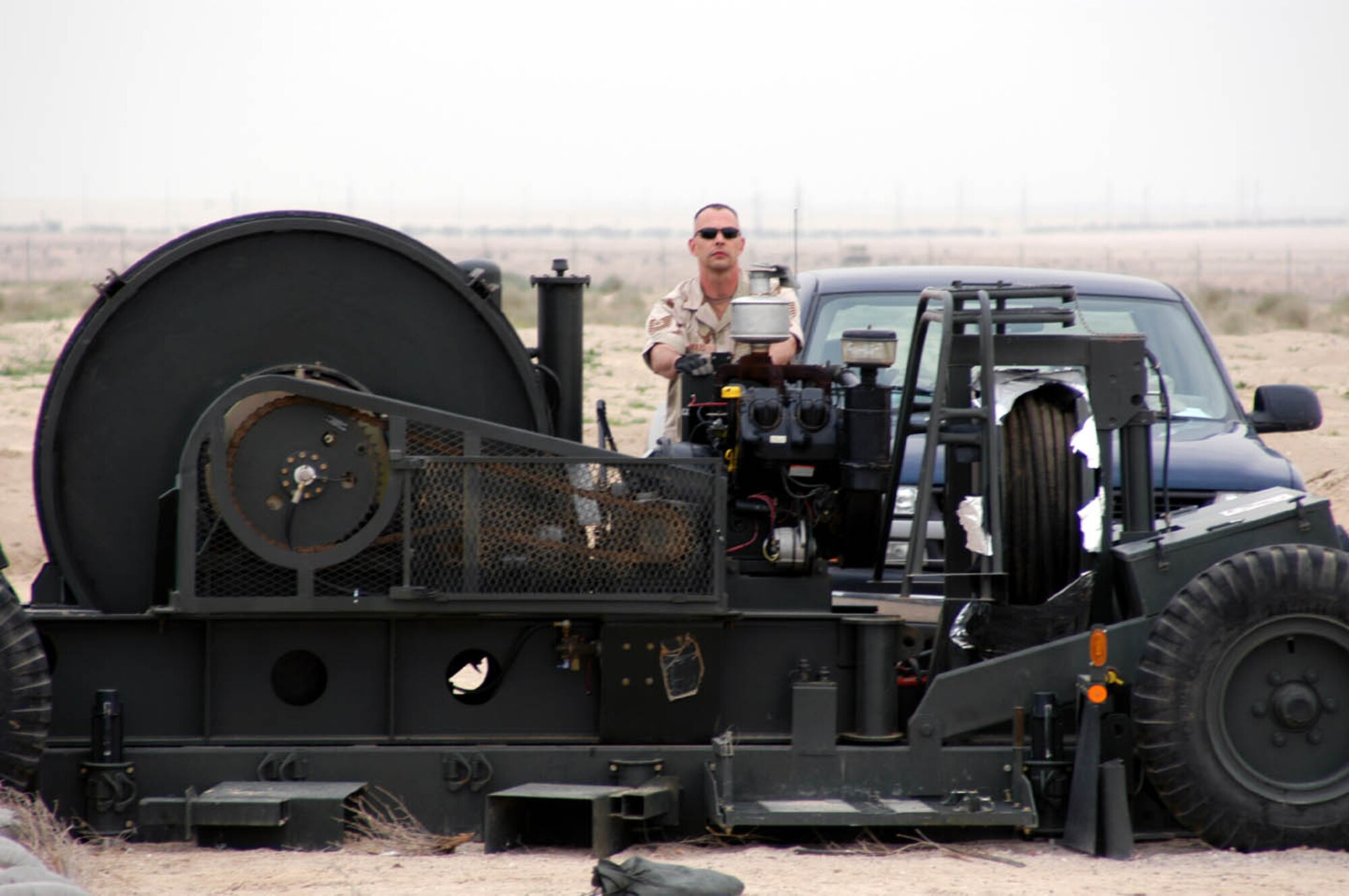 SOUTHWEST ASIA -- Tech Sgt. Brian Holes cranks the engine on one of the mobile aircraft arresting system at a forward-deployed location.  He is the 386th Expeditionary Civil Engineer power production flight superintendent.  (U.S. Air Force photo by Staff Sgt. William Farrow)
