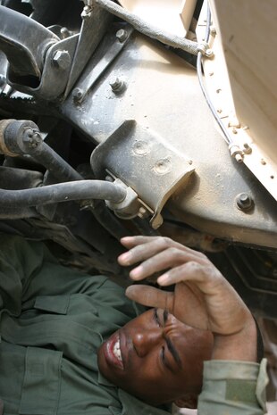Corporal Ratheon Mitchell, a Philadelphia native and mechanic with Headquarters and Service Battalion, 2d Force Service Support Group (Forward) motor pool, works underneath a humvee.  Mitchell and five other mechanics are responsible for maintaining nearly 70 pieces of equipment in the motor pool.  (Photo by Cpl. C.J. Yard)