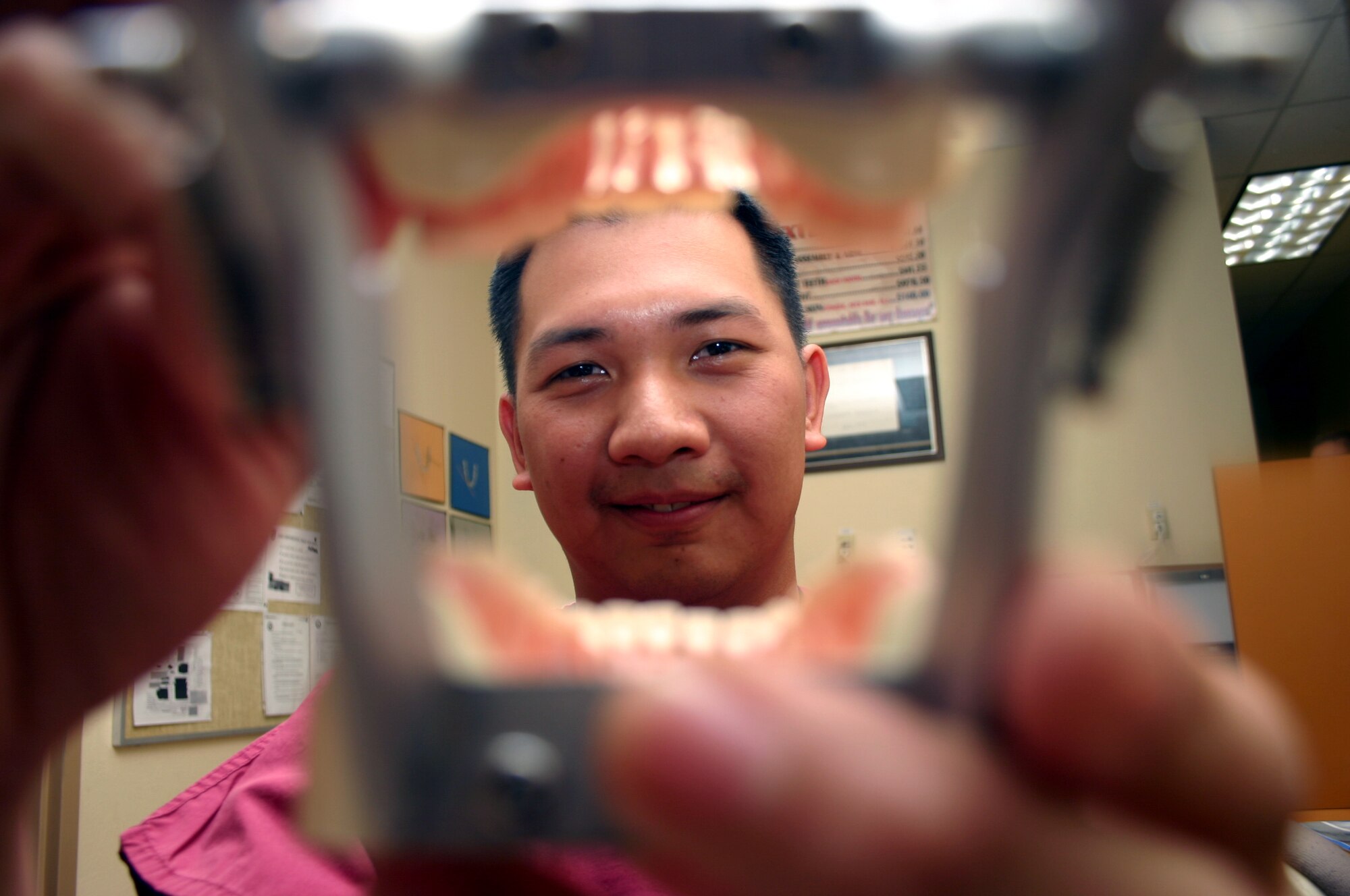 SHEPPARD AIR FORCE BASE, Texas -- Airman 1st Class Michael Dizon exams a model of teeth.  He was a dentist in the Philippines, but enlisted in the Air Force to become a dental technician.  He is working toward becoming an officer and is currently assigned to the 381st Training Squadron here.  (U.S. Air Force photo by Airman 1st Class Jacque Lickteig)