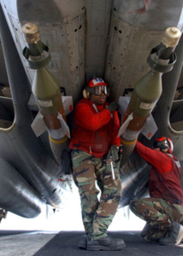 Navy Petty Officer 2nd Class Jamin Garnerhazelwood (center) inspects two laser guided bomb units mounted underneath an F-14B Tomcat during preparations for flight operations on the USS Harry S. Truman (CVN 75) on Feb. 24, 2005, while underway in the Persian Gulf. The Truman Strike Group and Carrier Air Wing 3 are conducting close air support, intelligence, surveillance, and reconnaissance missions over Iraq. Garnerhazelwood is a Navy aviation ordnanceman attached to Fighter Squadron 32 of Naval Air Station Oceana, Va. 