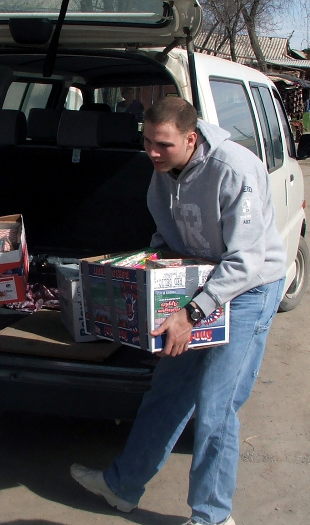 KHANABAD, Uzbekistan -- Senior Airman Jason Yarborough carries a box of humanitarian aid supplies for a local school during a visit here March 3.  A group of Airmen and Soldiers from nearby Karshi-Khanabad Air Base visited the village medical clinic and the school where they played a volleyball game and handed out donations.  (U.S. Air Force photo by Tech. Sgt. Scott T. Sturkol)