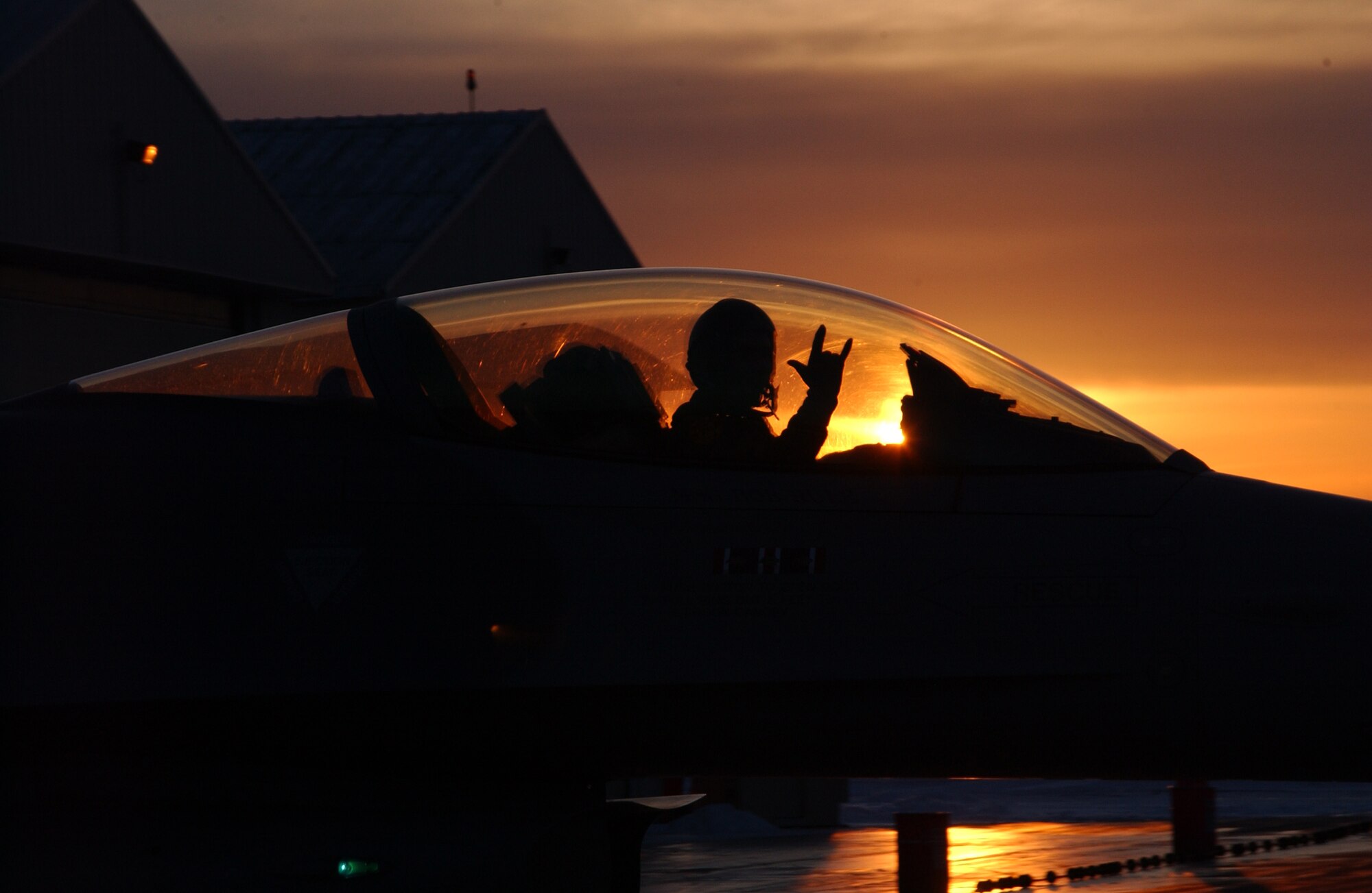 DULUTH, Minn. -- An F-16 Fighting Falcon pilot gives the mission accomplished sign while taxiing to the Arm/DeArm Pad here March 3. The pilot and F-16 are both assigned to the Minnesota Air National Guard's 148th Fighter Wing. (U.S. Air Force photo by Staff Sgt. Brett R. Ewald) 
