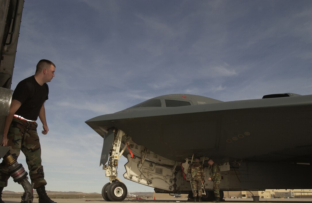 NELLIS AIR FORCE BASE, Nev. -- Senior Airman Kenneth Woods prepares to drag a fuel hose to refuel a B-2 Spirit bomber here March 1. Airman Woods is a fuel truck operator assigned to the 99th Logistics Readiness Squadron here and the B-2 is assigned to the 509th Bomb Wing at Whiteman AFB, Mo. (U.S. Air Force photo by Tech. Sgt. Thomas P. Dougherty)