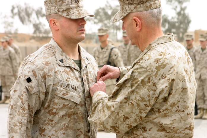 CAMP TAQADDUM, Iraq (March 11, 2005) - Corporal Stephen A. Reyna, a Marine with 6th Engineer Support Company, receives a Purple Heart from Brig. Gen. Andrew B. Davis, 4th Force Service Support Group Commanding General, during a ceremony held here March 9. Reyna, a 25-year-old Grand Rapids, Mich., native's vehicle was hit by a vehicle born improvised explosive device when returning from Operation Phantom Fury November 8.   The vehicle was severely damaged by the IED blast and immediately burst into flames. Reyna received minor wounds. Reyna is attached to the West Coast-based 1st FSSG in support of Operation Iraqi Freedom and prepares to return home after serving more than six months in Iraq. (Photo by Sgt. Kristin S. Jochums)