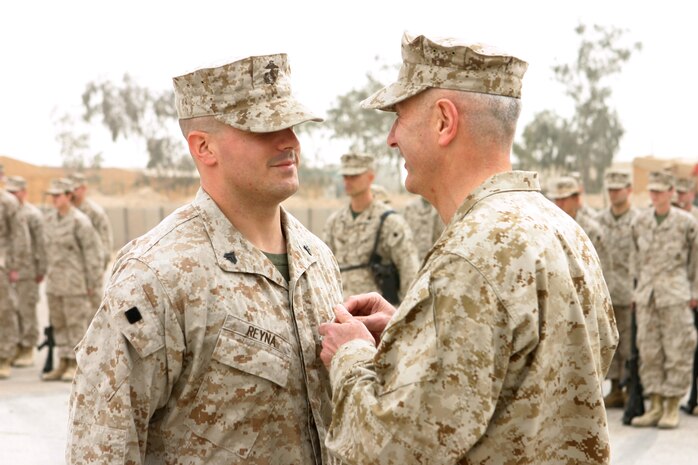 CAMP TAQADDUM, Iraq (March 11, 2005) - Corporal Stephen A. Reyna, a Marine with 6th Engineer Support Company, receives a Purple Heart from Brig. Gen. Andrew B. Davis, 4th Force Service Support Group Commanding General, during a ceremony held here March 9. Reyna, a 25-year-old Grand Rapids, Mich., native's vehicle was hit by a vehicle born improvised explosive device when returning from Operation Phantom Fury November 8.   The vehicle was severely damaged by the IED blast and immediately burst into flames. Reyna received minor wounds. Reyna is attached to the West Coast-based 1st FSSG in support of Operation Iraqi Freedom and prepares to return home after serving more than six months in Iraq. (Photo by Sgt. Kristin S. Jochums)