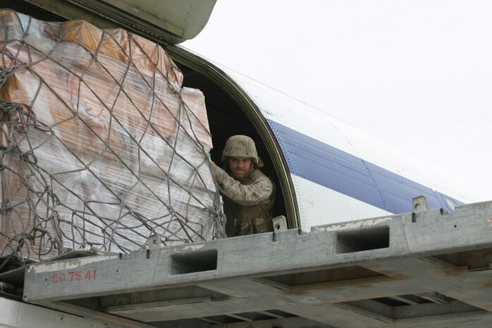 CAMP TAQADDUM, Iraq (March 11, 2005) - Lance Cpl. David A. Sadler, a native of Bourbonnais, Ill., helps unload one of the 14 pallets of mail received here March 9. The 24-year-old 2d Force Service Support Group (Forward) postal clerk is one of 24 Marines who assumed postal responsibilities from 1st FSSG during a mass turn over of troops here in support of Operation Iraqi Freedom. (Photo by Sgt. Kristin S. Jochums)