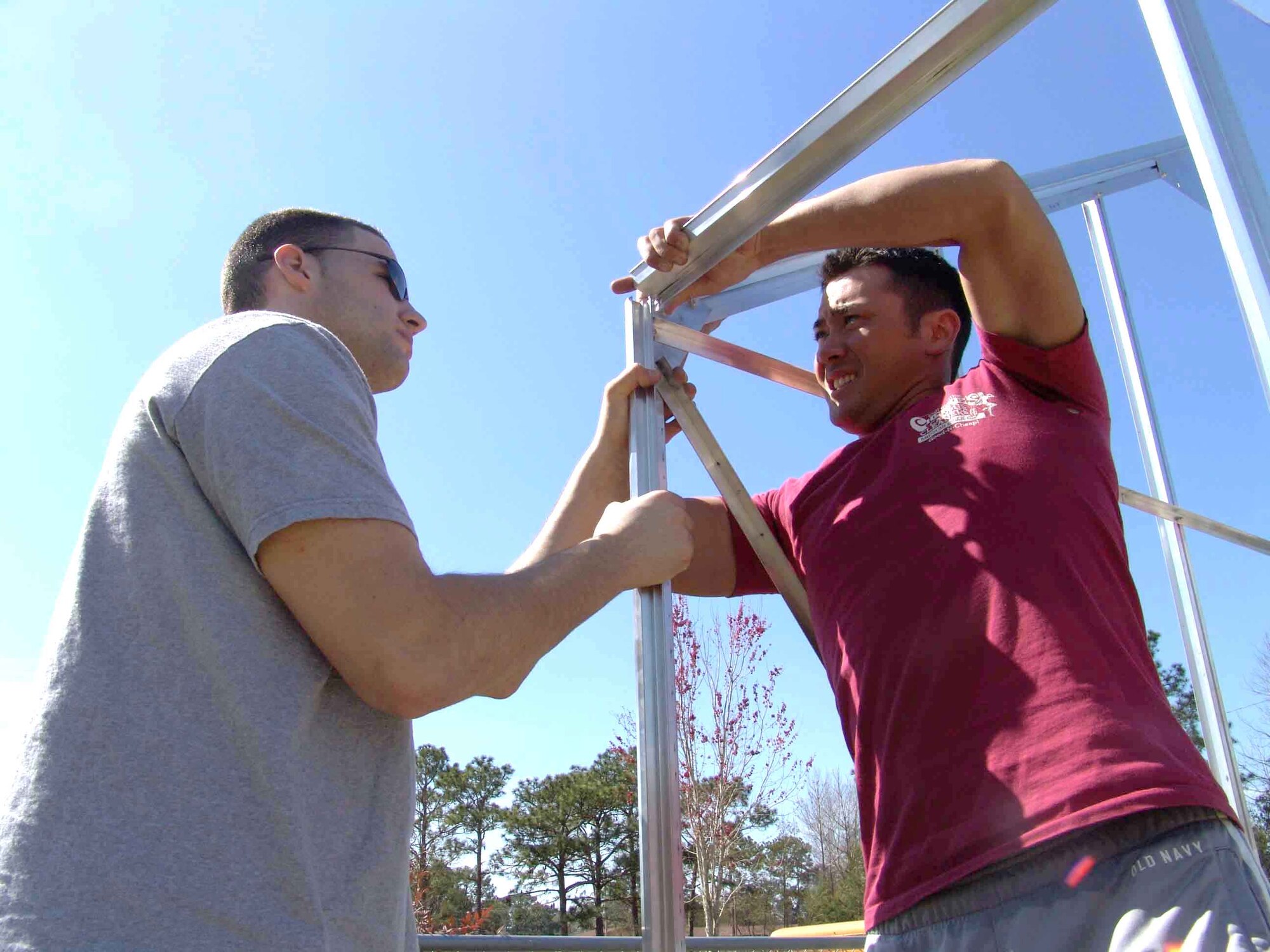VALPARAISO, Fla. -- Airmen 1st Class Brian Wiechec (left) and Daniel Springer connect two sides of a greenhouse frame at an elementary school here.  Hurricane Ivan destroyed the school's greenhouse in September.  More than 15 Airmen from nearby Elgin Air Force Base and Duke Field helped build a replacement.  Airmen Wiechec and Springer are assigned to the 716th Maintenance Squadron at Duke.  (U.S. Air Force photo by 2nd Lt. Kristen D. Duncan)