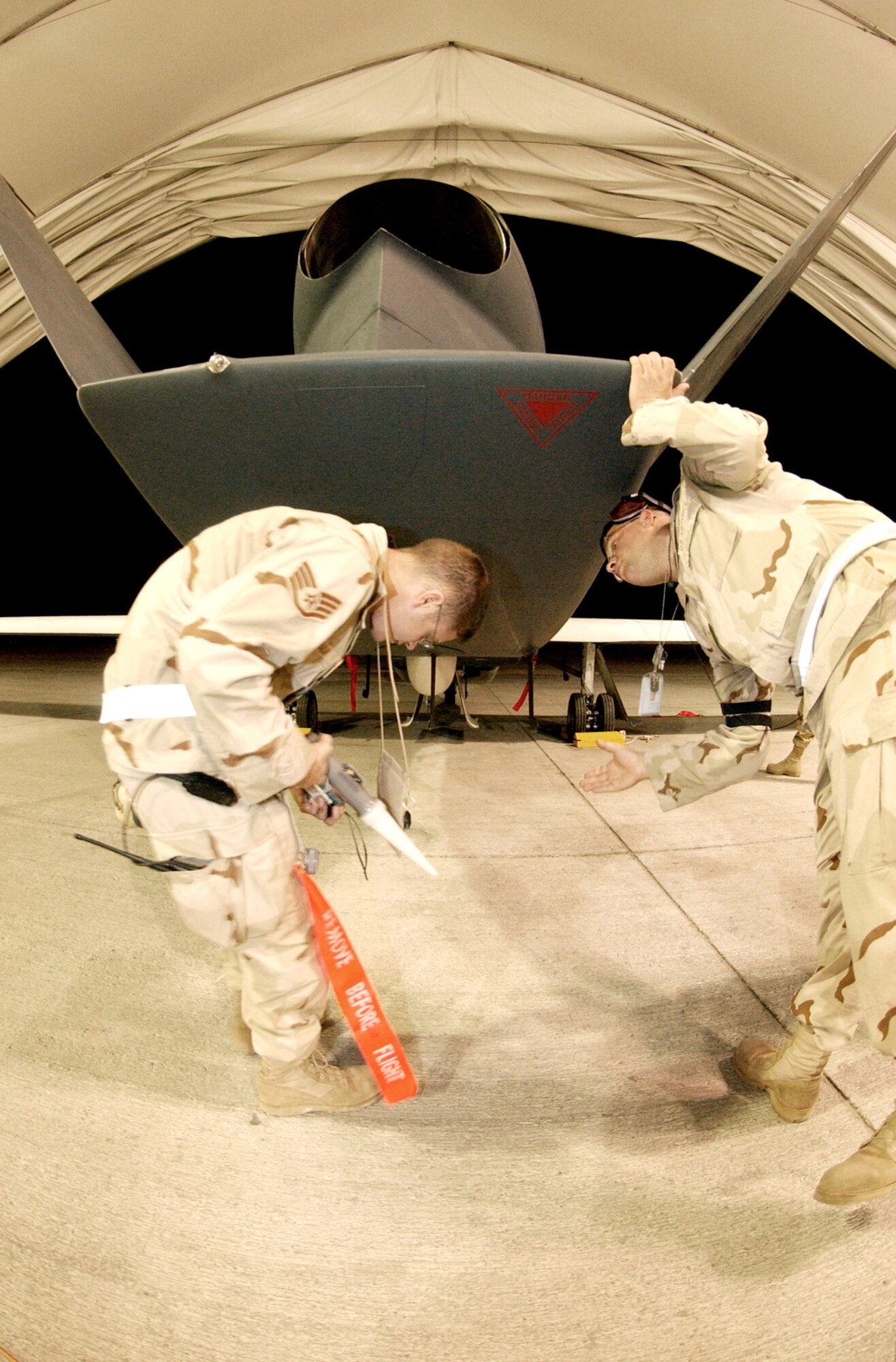 SOUTHWEST ASIA -- Staff Sgt. Sean Haugan and Staff Sgt. Brian Fox examine a Global Hawk unmanned aerial vehicle just before launch.  The Airmen are deployed to the 380th Expeditionary Aircraft Maintenance Squadron.  (U.S. Air Force photo by Staff Sgt. Justin Jacobs)