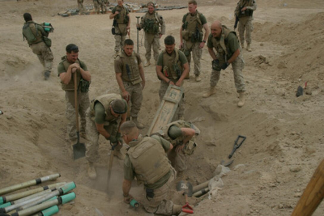 U.S. Marines remove one of several cases of ordnance found in a weapons cache buried outside of Kharma, Iraq, on March 3, 2005. The Marines are from the 2nd Combat Engineer Battalion, attached to the 3rd Battalion, 8th Marine Regiment, and are engaged in security and stabilization operations in the Al Anbar Province, Iraq. 