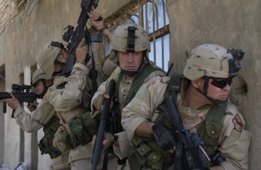 U.S. Army soldiers form up along a wall as they prepare to clear a building known to house insurgents in an area of Al Iskandariyah, Iraq, on March 5, 2005. The soldiers are assigned to the 1st Scout Platoon, Delta Company, 155th Brigade Combat Team. 