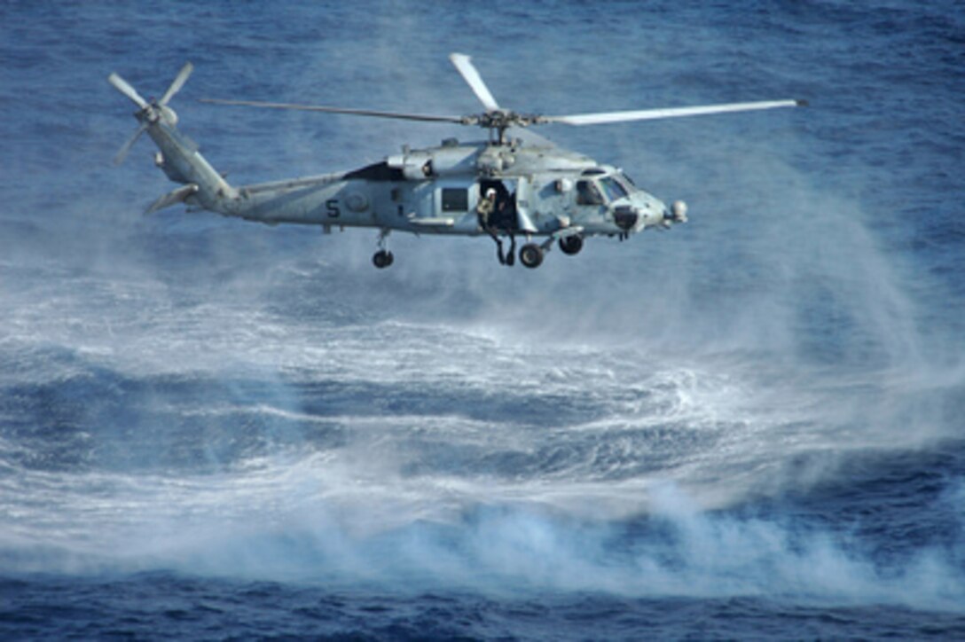 A Navy HH-60H Seahawk hovers over the Pacific Ocean as it prepares to put two swimmers attached to an Explosive Ordnance Disposal detachment in the water to detonate a simulated mine during a training exercise on March 8, 2005. EOD technicians routinely train to locate and disarm various explosive devices. The Seahawk is attached to Helicopter Anti- submarine Squadron 14 of Naval Air Station Atsugi, Japan. The EOD technicians and the Seahawk are operating from the aircraft carrier USS Kitty Hawk (CV 63). 