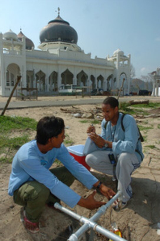 U.S. Navy Petty Officer 3rd Class Ron Berard (right) labels a water sample taken from an Internally Displaced Persons Camp, in Banda Aceh, Indonesia, on March 9, 2005. Berard is a Navy hospital corpsman attached to the Navy Environmental Preventive Medicine Unit 6. Berard's unit is conducting daily operations at the camps to assess health concerns including water and soil studies, disease and vector control in support of Operation Unified Assistance in Banda Aceh, Indonesia. 