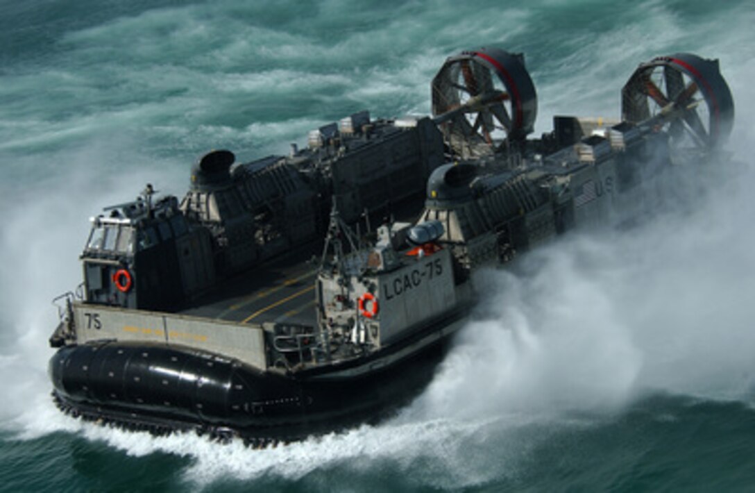 A U.S. Navy Landing Craft Air Cushion, more commonly known as an LCAC, kicks up spray as it heads to the Kuwait Naval Base from the amphibious dock landing ship USS Harpers Ferry (LSD 49) on March 5, 2005. Harpers Ferry is part of Expeditionary Strike Group 3 and is currently deployed to the Persian Gulf in support of Operation Iraqi Freedom. The LCAC is attached to Assault Craft Unit 5 at Camp Pendleton, Calif., and is deployed aboard the Harpers Ferry. 