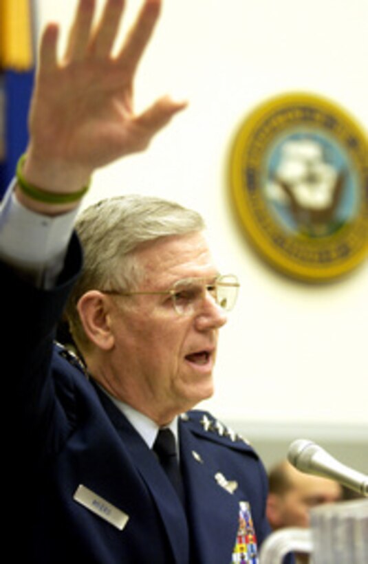 Chairman of the Joint Chiefs of Staff Gen. Richard B. Myers, U.S. Air Force, raises his arm in a gesture as he responds to a representative's question during a House Armed Services Committee hearing in the Rayburn House Office Building in Washington, D.C., on March 10, 2005. Myers joined Secretary of Defense Donald H. Rumsfeld and Under Secretary of Defense Comptroller Tina Jonas in testifying before the committee. 