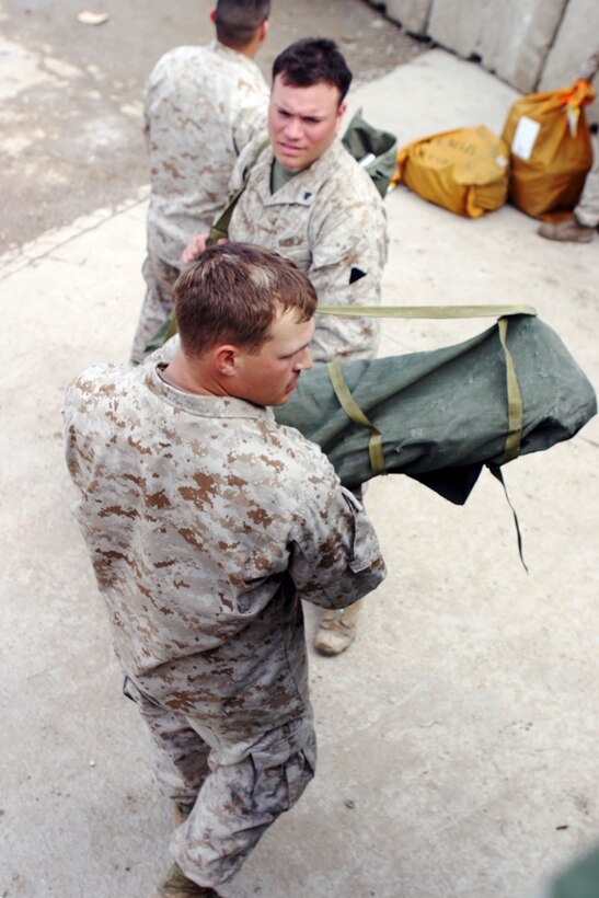 Corporals Erik J. Olson and Lester Laracuente with the 15th Marine Expeditionary Unit (Special Operations Capable) load an Optical Element 254 antenna into a HMMWV while establishing communications here. Olson, 23, is a field radio operator and native of Mason City, Iowa, and Laracuente, 21, is a field radio operator and native of Ponce, Puerto Rico.  The 15th MEU is currently conducting security and stability operations here in the greater Baghdad area.