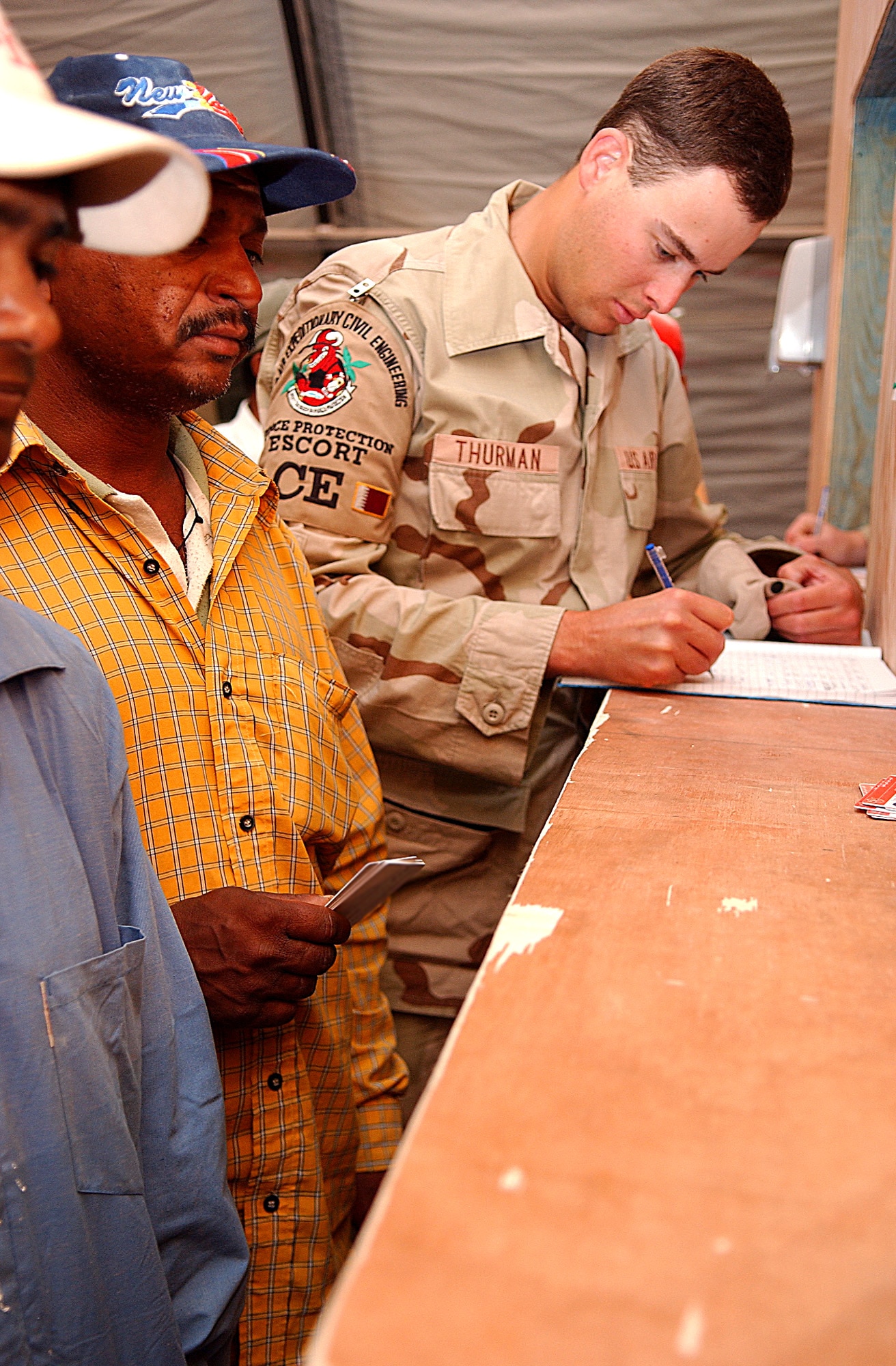 SOUTHWEST ASIA -- Airman 1st Class Matthew Thurman completes paperwork that will give several foreign workers restricted access to the base.   He is a 379th Expeditionary Civil Engineer Squadron escort.  (U.S. Air Force photo by Staff Sgt. Colette Bennett)
