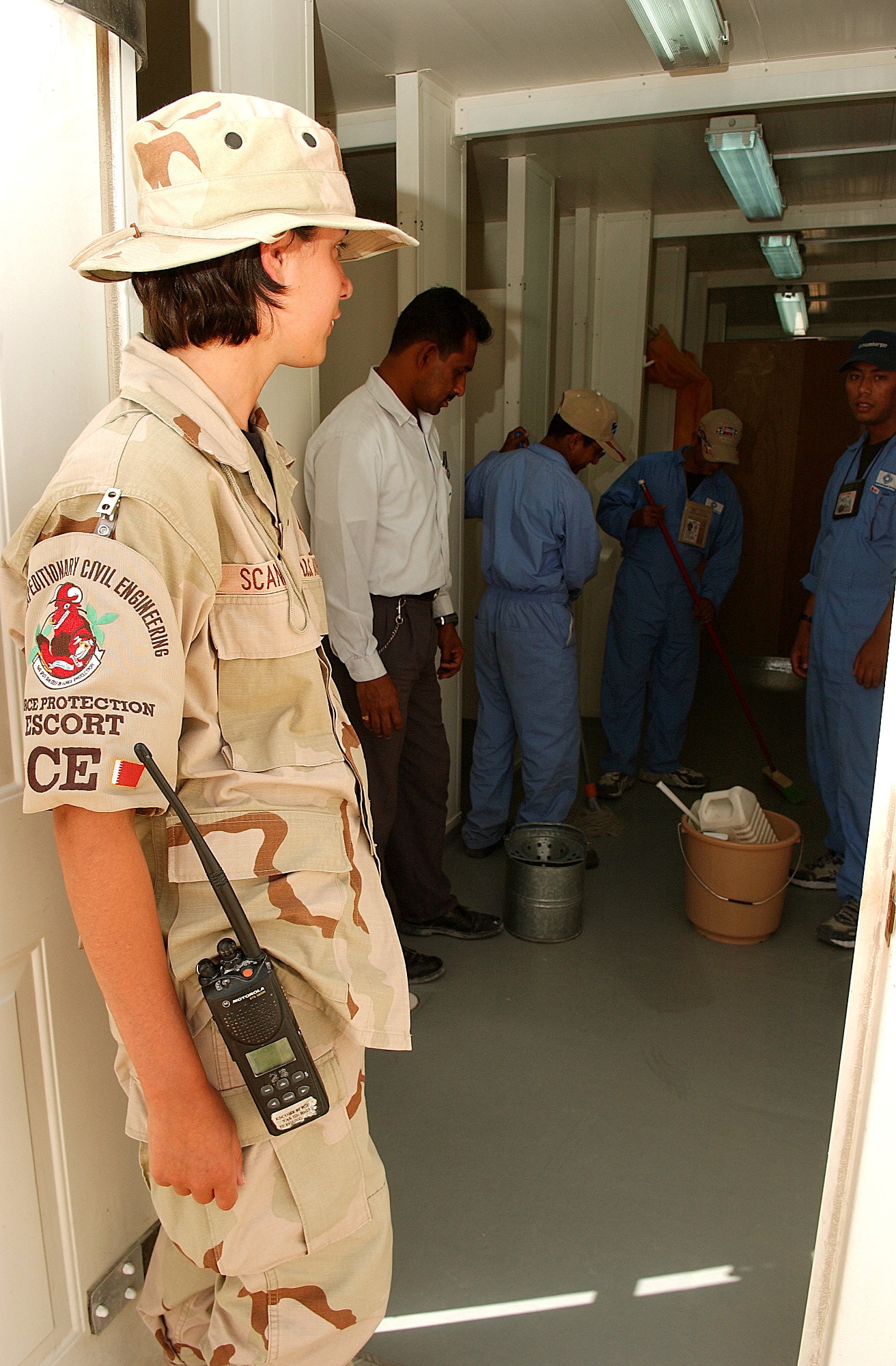 SOUTHWEST ASIA -- Senior Airman Erin Scannell observes workers.  She is a 379th Expeditionary Civil Engineer Squadron escort.  (U.S. Air Force photo by Staff Sgt. Colette Bennett)