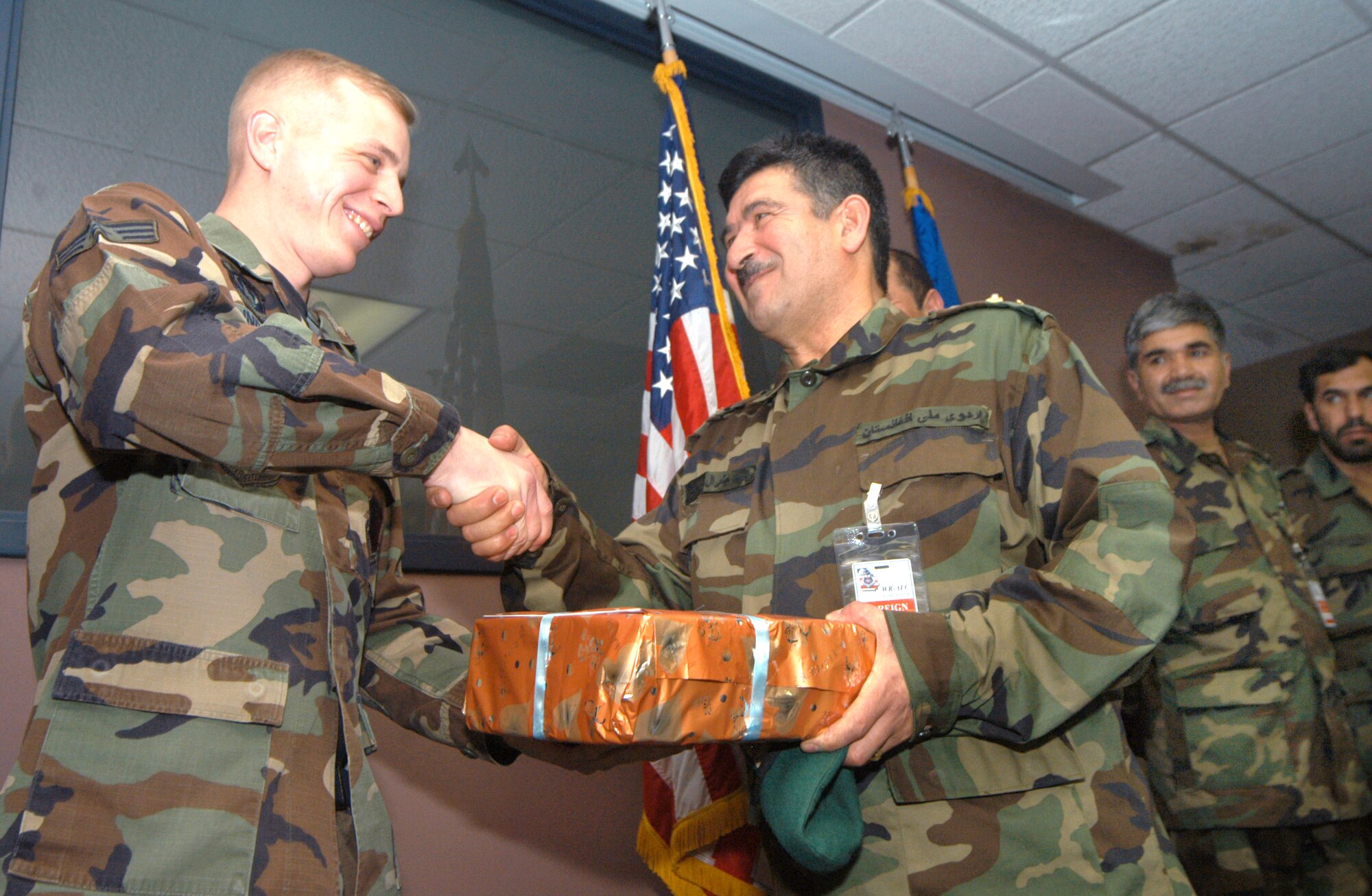 ROBINS AIR FORCE BASE, Ga. -- Senior Airman Jason Lindgren accepts a gift from Afghan Brig. Gen. Baba Mirza and other Afghan officers here March 11.  Airman Lindgren is a 78th Communications Squadron computer networking specialist, and he helped establish a computer network system for the Afghan military.  (U.S. Air Force photo by Sue Sapp)
