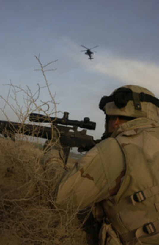 U.S. Army Spc. Alex Aguilar watches over a part of the Euphrates River that insurgents use to transport mortars and weapons in the hours of darkness in Al Iskandariyah, Iraq, on March 9, 2005. Aguilar is assigned as a sniper from Alpha Company, 1st Battalion, 155th Brigade Combat Team. 