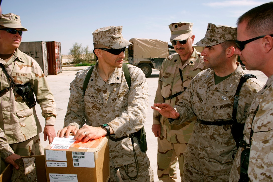 AL ASAD, Iraq -- Lieutenant Col. Carmine J. Borrelli, Marine Aviation Logistics Squadron 26 (Reinforced) commanding officer, discusses the flow of parts and supplies from the United States to Iraq with Lt. Col. Seth Hathaway, aviation supply readiness officer for Commander, Naval Air Force on March 15.  Hathaway and other Marines and sailors from CNAF were here recently to assess the readiness of the squadrons participating in Operation Iraqi Freedom.