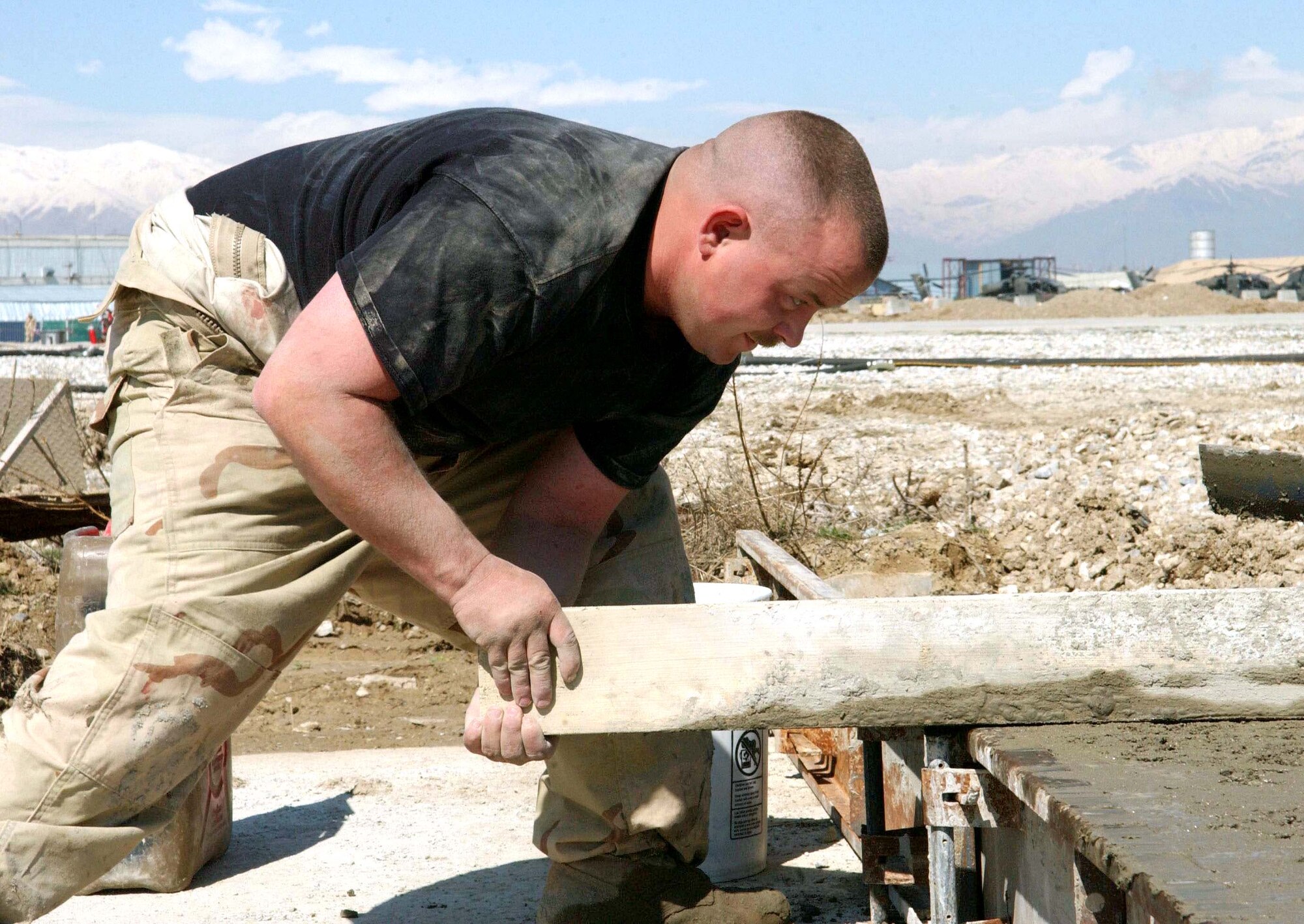 BAGRAM AIR BASE, Afghanistan -- Senior Airman Chris Bender levels the concrete in one of the 28 cast runway replacement slabs destined for the 9,800-foot runway here.  He is assigned to the 455th Expeditionary Civil Engineer Squadron.  (U.S. Air Force photo by Capt. Catie Hague) 