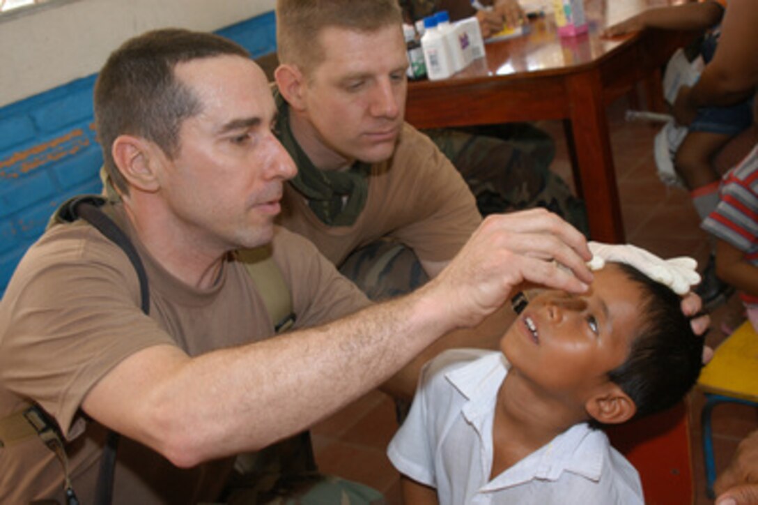 Navy Nurse Lt. William Jansak (left) applies eye drops to a young Nicaraguan boy during a Medical Readiness Training Exercise in Palo Grande, Chinandega, Nicaragua, on March 10, 2005. Jansak is attached to the Operational Health Support Unit Great Lakes, Ill., and is deployed to Nicaragua as part of New Horizons 2005, a joint-combined services engineering and humanitarian aid mission that will see the construction of four schools and two medical clinics in Nicaragua. 