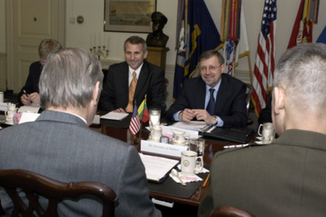 Lithuanian Minister of Defense Gediminas Kirkalas (center right) accompanied by Ambassador Vygaudas Usackas (left) meets with Secretary of Defense Donald H. Rumsfeld (foreground) in the Pentagon on March 15, 2005. Kirkalas and Rumsfeld are meeting to discuss defense issues of mutual interest. 