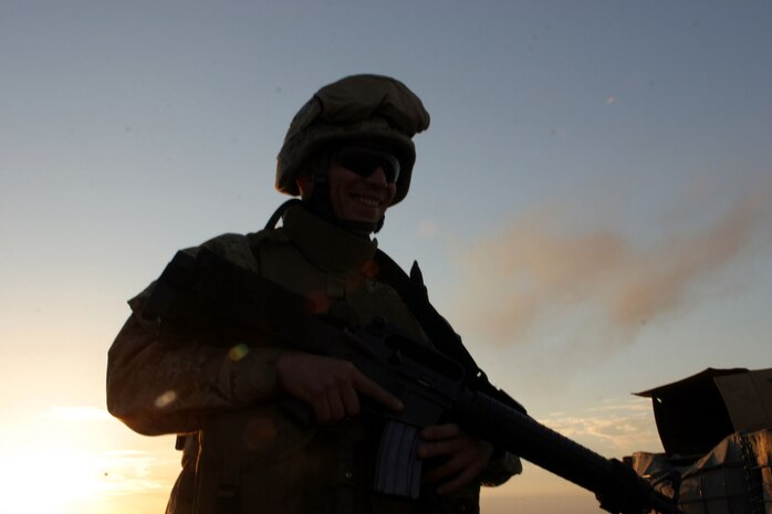 CAMP TAQADDUM, Iraq - Private First Class John Super, an ammunition technician, from Kansas City, Kansas, mans an observation post along the edge of the base here. Super, 28, volunteered to deploy to Iraq with his reserve unit, general support ammunition platoon, Ammunition Company, 4th Supply Battalion, 4th Force Service Support Group from Topeka, Kansas, but never thought he would find himself standing watch over the barren landscape of Iraq. Super is assigned to the Provisional Rifle Company, Headquarters and Service Bn., 2d Marine Logistics Brigade (Forward), based out of Camp Lejeune, N.C. (Photo by Cpl. C.J. Yard)