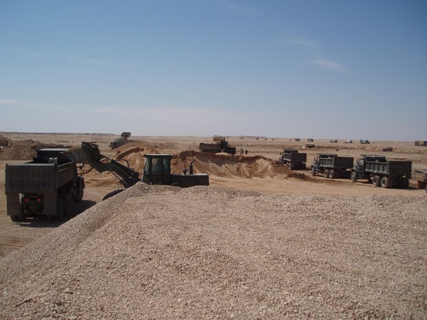 Iraq -- Marines operating tractor rubber-tired articulated-steering multi-purpose loaders, loads  dump trucks during Operation Bedrock.  A joint effort between the Army, Seabees and Marines from heavy equipment platoon, 8th Engineer Support Battalion, 2d Force Service Support Group (Forward).  The service members harvested 3,800 cubic yards of gravel during the operation.  The service members spent five of six nights at the quarry to get the TRAMs up and running to ensure timeliness of the operation.