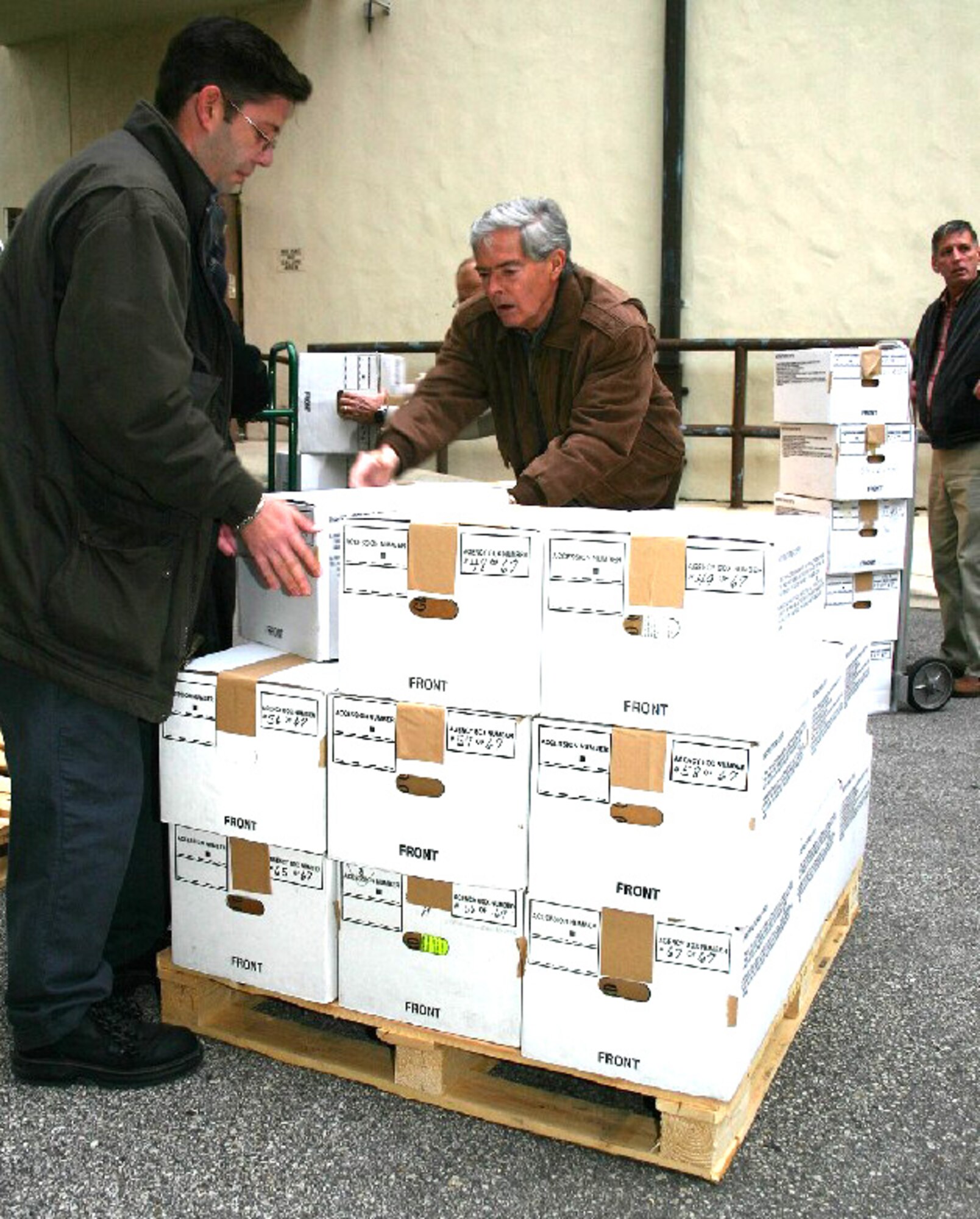 RANDOLPH AIR FORCE BASE, Texas -- Sam Ballard and Robert Weston load file boxes of records onto a pallet here in February.  The boxes were part of the final 1,800 records in paper form to be delivered to the National Personnel Records Center in St. Louis.  The automated records management systems branch here will soon process all records in an electronically scanned format. (U.S. Air Force photo by Tech. Sgt. James Brabenec)