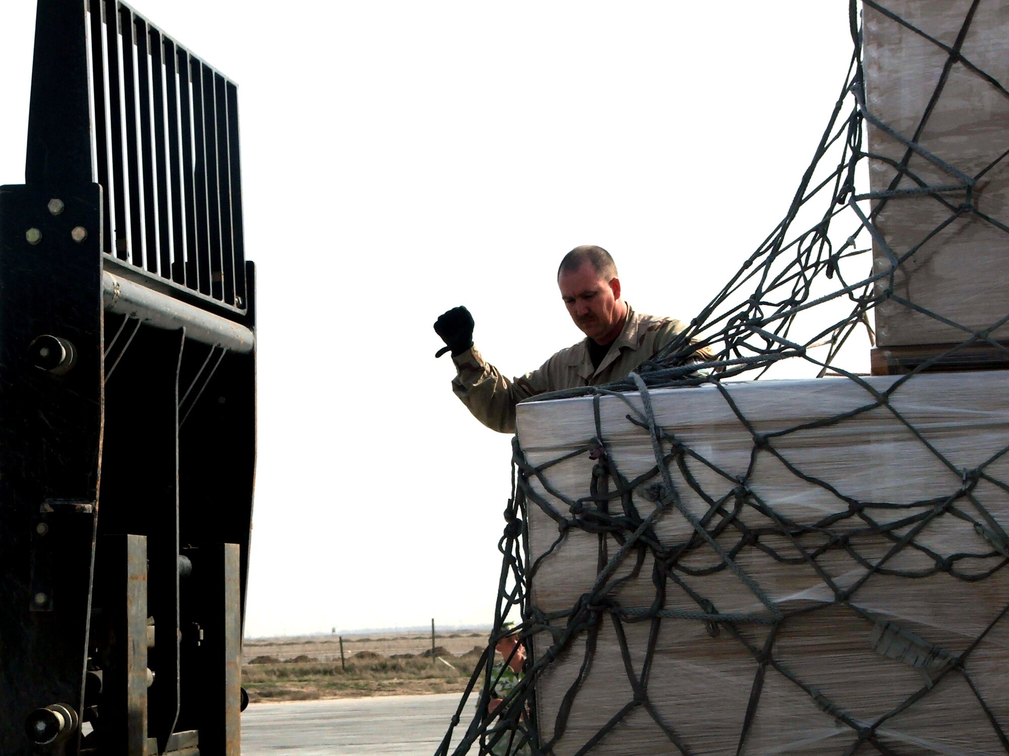 KARSHI-KHANABAD AIR BASE, Uzbekistan -- Tech. Sgt. Bringham Norman guides a forklift into place while moving a pallet filled with mail here recently.  He is an air transportation craftsman with the 416th Expeditionary Mission Support Squadron's Air Terminal Operations Center from Maxwell Air Force Base, Ala.  (U.S. Air Force Photo by Tech. Sgt. Scott T. Sturkol)