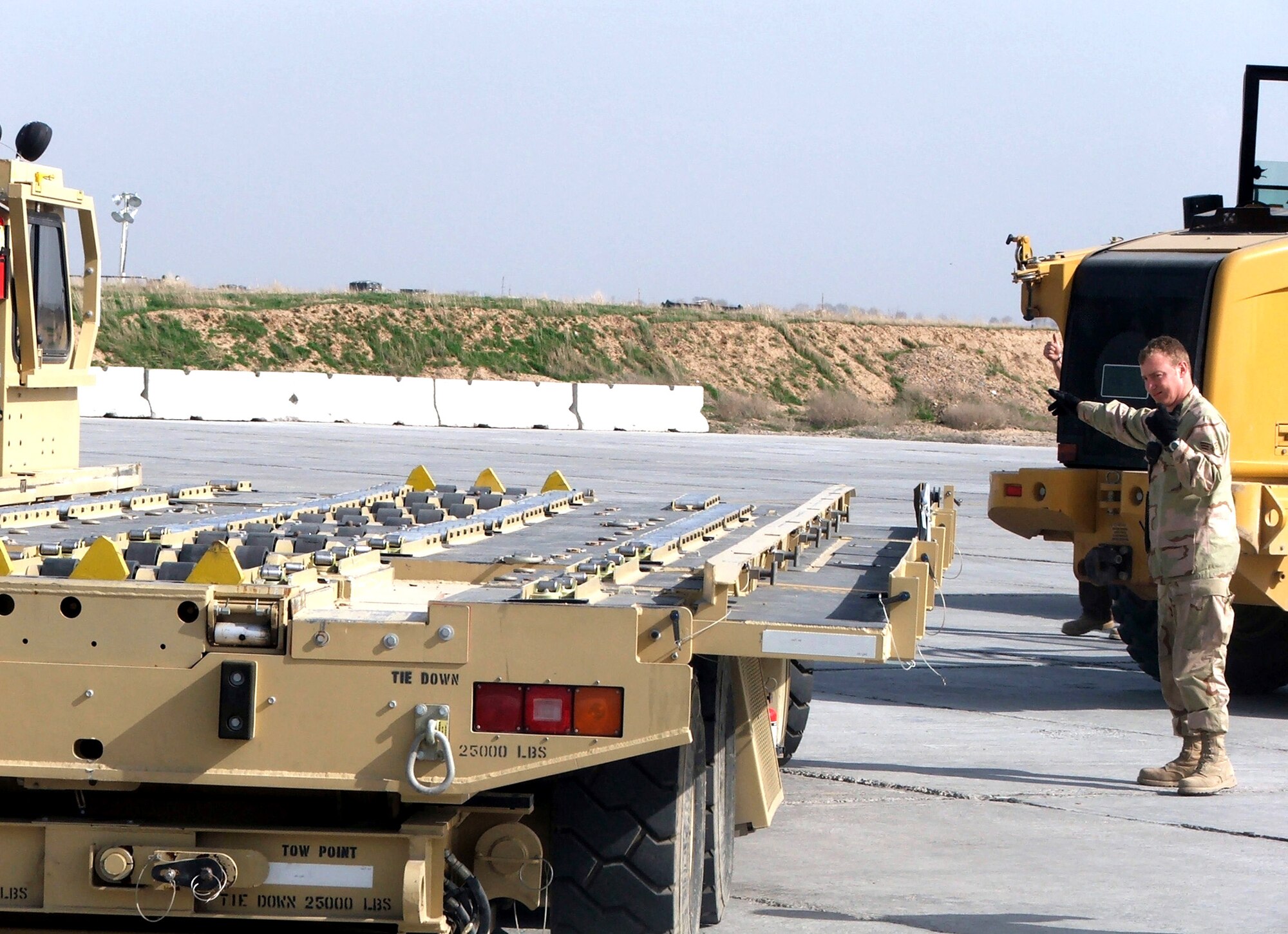 KARSHI-KHANABAD AIR BASE, Uzbekistan -- Senior Airman Fred Koehl guides the driver of an aircraft loader here recently.  He is an air transportation journeyman deployed here with the 416th Expeditionary Mission Support Squadron's Air Terminal Operations Center from Maxwell Air Force Base, Ala.  (U.S. Air Force Photo by Tech. Sgt. Scott T. Sturkol)