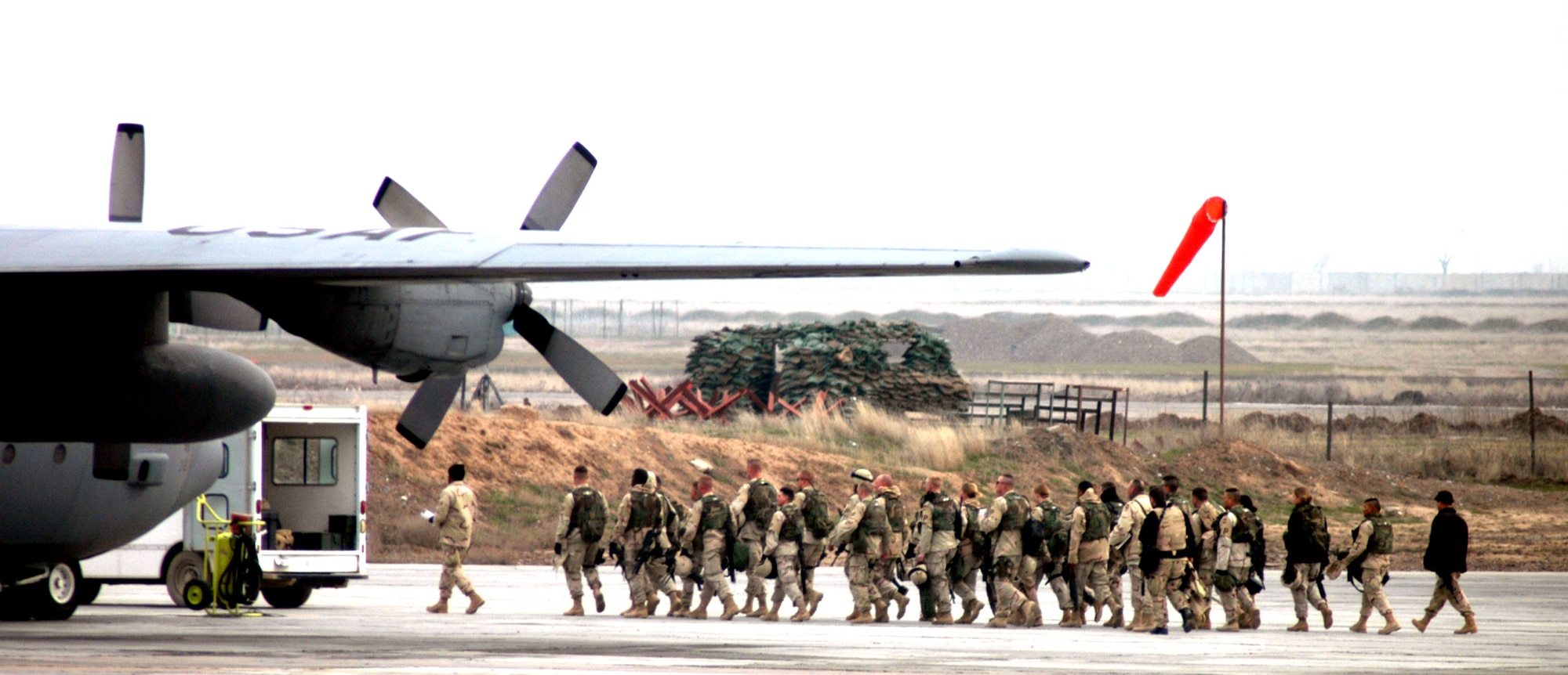 KARSHI-KHANABAD AIR BASE, Uzbekistan -- Army troops follow an Airman of the 416th Expeditionary Mission Support Squadron's Air Terminal Operations Center as they walk across the flightline on their way to a C-130 Hercules to fly to a forward-deployed location supporting Operation Enduring Freedom.  (U.S. Air Force Photo by Tech. Sgt. Scott T. Sturkol)