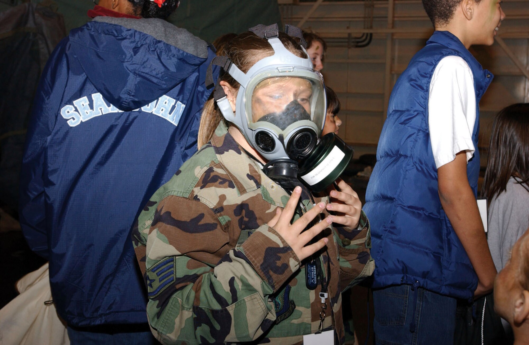 KADENA AIR BASE, Japan -- Logan Deremer, 10, tries on a gas mask to experience what her dad would go through if he had to use one while deployed.  It was part of an Operation Kids Understanding Deployment Operations event March 12.  Logan is the daughter of Staff Sgt. David Deremer of the 18th Communications Squadron.  (U.S. Air Force photo by Senior Airman Mercedes McAlister)