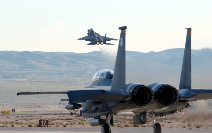NELLIS AIR FORCE BASE, Nev.  -- An F-15 Eagle takes off into the morning sky as another one taxis out on the tarmac. Aircraft, aircrews, maintainers and support Airmen from around the world are here participating in Red Flag, an exercise that tests warfighting skills in real-time combat situations. (U.S. Air Force photo by Tech. Sgt. Roy A. Santana)

