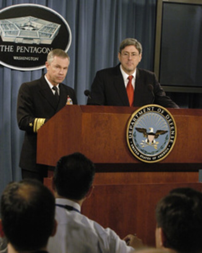 Vice Director for Strategic Plans and Policy for the Joint Chiefs of Staff Rear Adm. William D. Sullivan, U.S. Navy, (left) and Under Secretary of Defense for Policy Douglas J. Feith listen to a reporter's question during their briefing on National Defense Strategy and National Military Strategy in the Pentagon on March 18, 2005. Feith states that these strategies outline an active, layered approach to the defense of the nation and its interests. 