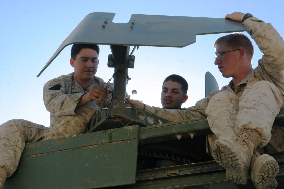 Lance Cpl. Kevin P. Long (left) 21, a native of Port Orchard, Wash., Cpl. Esteban Vela (center), 23, a native of San Antonio, and Lance Cpl. Matthew W. Fleming, 20, a native of Columbus, Ohio, check the turret armor recently installed on a 7-ton truck. The Marines, all Logistics Vehicle System Operators with MEU Service Support Group 15, are in Iraq conducting security and stability operations with their unit.