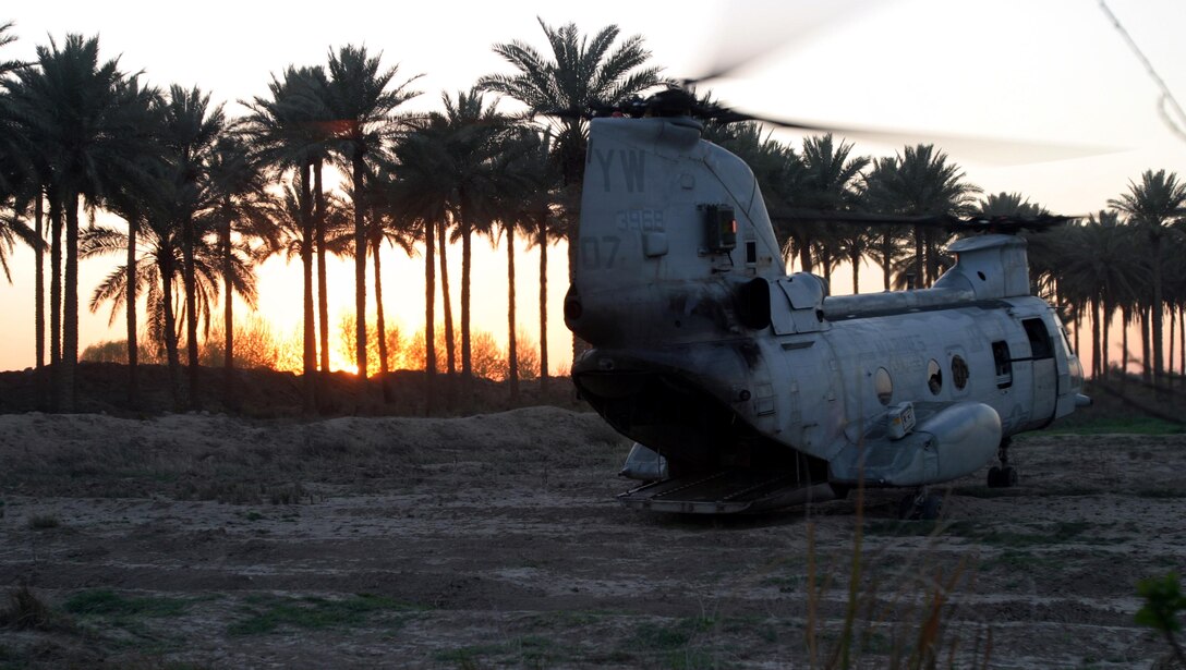 BAGHDAD, Iraq -- (Mar. 19, 2005) -  A CH-46E Sea Knight helicopter with the 15th Marine Expeditionary Unit (Special Operations Capable) sits at a Bravo Company's patrol base as the sun sets behind a palm grove in Baghdad farming community. The 15th Marine Expeditionary Unit (Special Operations Capable) is conducting security and stabilization operations in the Greater Baghdad area.