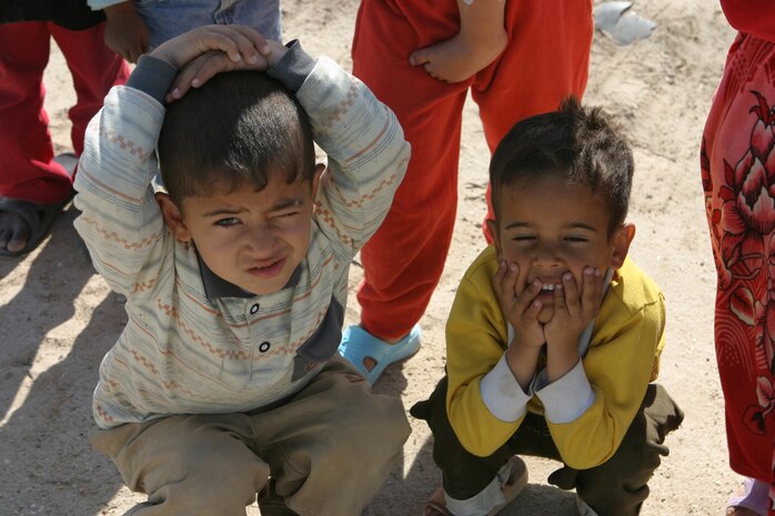 CAMP TAQADDUM, Iraq (March 29, 2005) - Two Iraqi boys stop to pose for the camera while service members visit their village. The 2d Force Service Support Group (Forward) Marines, along with Soldiers from 2nd Battalion, 112th Armor, 36th Infantry Division visit the local villages of Al Kabani and Quiadisisya to hand out soccer balls and backpacks filled with school supplies. Along with the humanitarian visits, contracts for water towers, septic filtration systems and mosque improvements were agreed upon between the village sheiks and the 2/112th. (Photo by Sgt. Kristin S. Jochums)