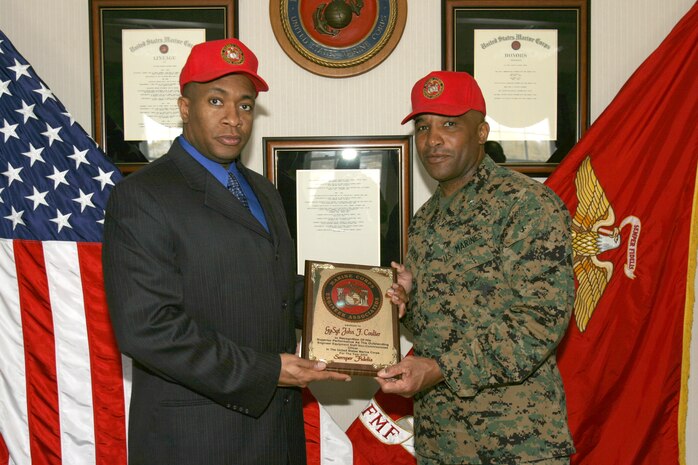 MARINE CORPS BASE CAMP LEJEUNE, N.C. (March 22, 2005) - Retired Gunnery Sgt. John F. Coulter receives a plaque from Brig. Gen. Ronald S. Coleman, the 2nd Force Service Support Group commanding general, here in the 2nd FSSG headquarters building March 22. The plaque, from the Marine Corps Engineer Association, names Coulter, a Jacksonville, N.C., native, as the Outstanding Engineer Equipment Staff Noncommissioned Officer in the Marine Corps for 2004. The two are wearing hats from the association. (Official U.S. Marine Corps photo by Lance Cpl. Bobby J. Segovia)