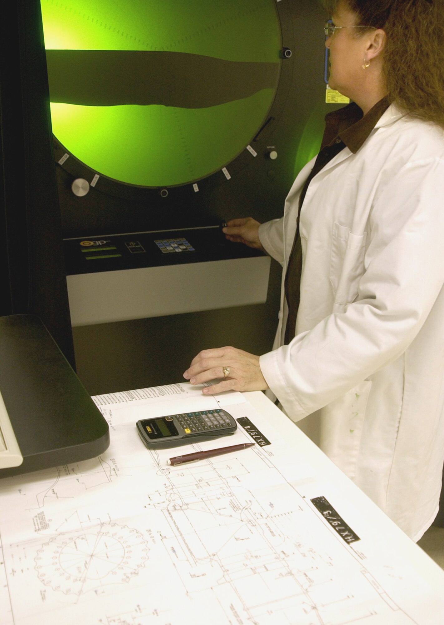 HILL AIR FORCE BASE, Utah -- Connie Adams uses an optical comparator to measure the mold of a cylinder.  This machine is the only way to measure internal features.  Ms. Adams is an engineering technician in the quality verification center here.  (Courtesy photo)