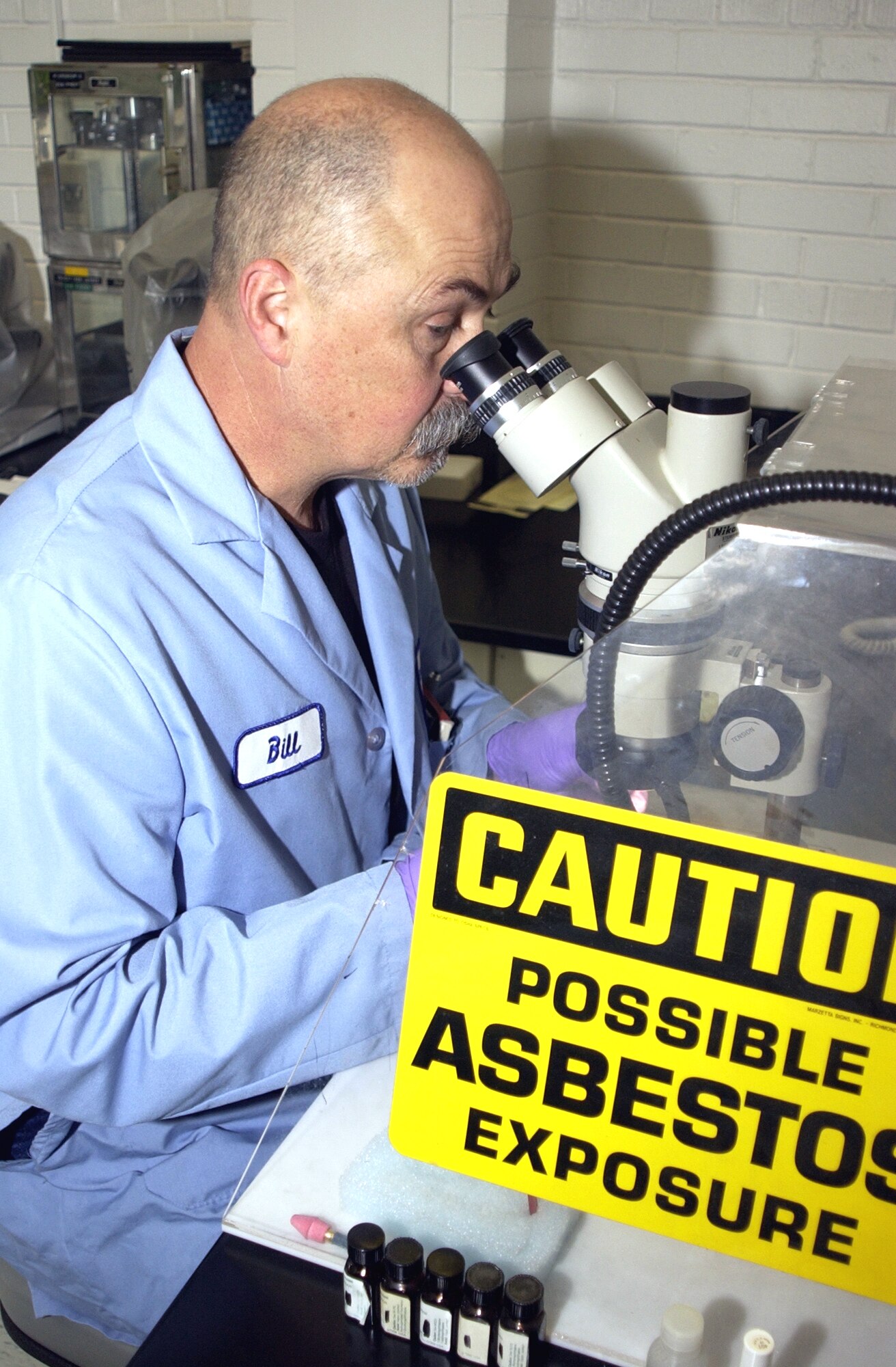 HILL AIR FORCE BASE, Utah -- Bill Comeau, an engineering technician, searches for asbestos fibers under a microscope.  (Courtesy photo)