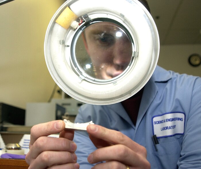 HILL AIR FORCE BASE, Utah -- Dan Farley, a materials engineer, examines a fracture surface of an F-16 Fighting Falcon's main landing gear that failed.  (Courtesy photo)