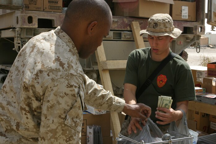 AL ASAD, Iraq (March 25, 2005) - Lance Cpl. Jeffery Cipro, a foodservices Marine with 3rd Battalion, 25th Marine Regiment, purchases cigarettes and snack food for himself and several of his fellow Marines during a Warfighter Express Services Team operation, in Hit, Iraq, March 23. The Massillon, Ohio, native was one of about 200 Marines and other U.S. service members who visited the WES team during this operation. WES Teams bring exchange, postal and disbursing services to service members stationed in the remote regions of Iraq where such services are not normally available. (Photo by: Cpl. John E. Lawson Jr.)
