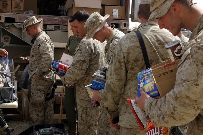 AL ASAD, Iraq (March 25, 2005) - Marines and other U.S. service members stationed in Hit, Iraq, line up to purchase cigarettes, candy, snack foods and various other items from the mobile exchange March 23. Marines from Headquarters and Service Battalion and Combat Logistics Battalion - 2, 2d Marine Logistics brigade (Forward), conducted Warfighter Express Services Team operation, offering exchange, postal and disbursing services to about 200 service members during this trip. (Photo by: Cpl. John E. Lawson Jr.)