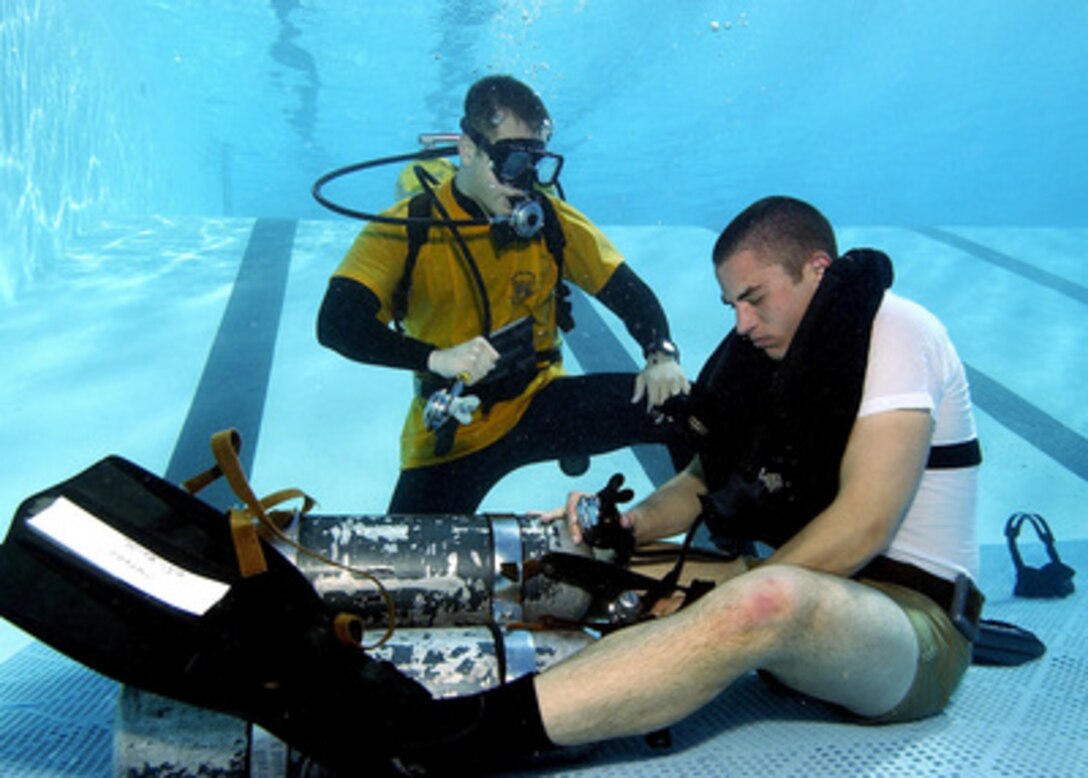 A Navy diving instructor (left) stands ready to offer a diving student air if he is not able to regain his own air supply during a problem solving exercise at the Naval Diving and Salvage Training Center in Panama City, Fla., on Feb. 9, 2005. The carefully supervised exercise is designed to train students to remain calm during a loss of air situation while following carefully supervised procedures to regain their air supply without going to the surface. 