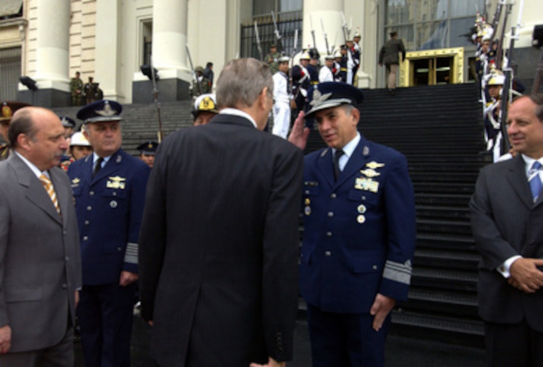 Secretary of Defense Donald H. Rumsfeld (center) is greeted by a member of Argentina's Minister of Defense Jose Pampuro's staff outside the Ministry of Defense in Buenos Aires, Argentina on March 22, 2005. Rumsfeld is traveling to Latin America to meet with key government officials and to strengthen bilateral ties with Argentina. 